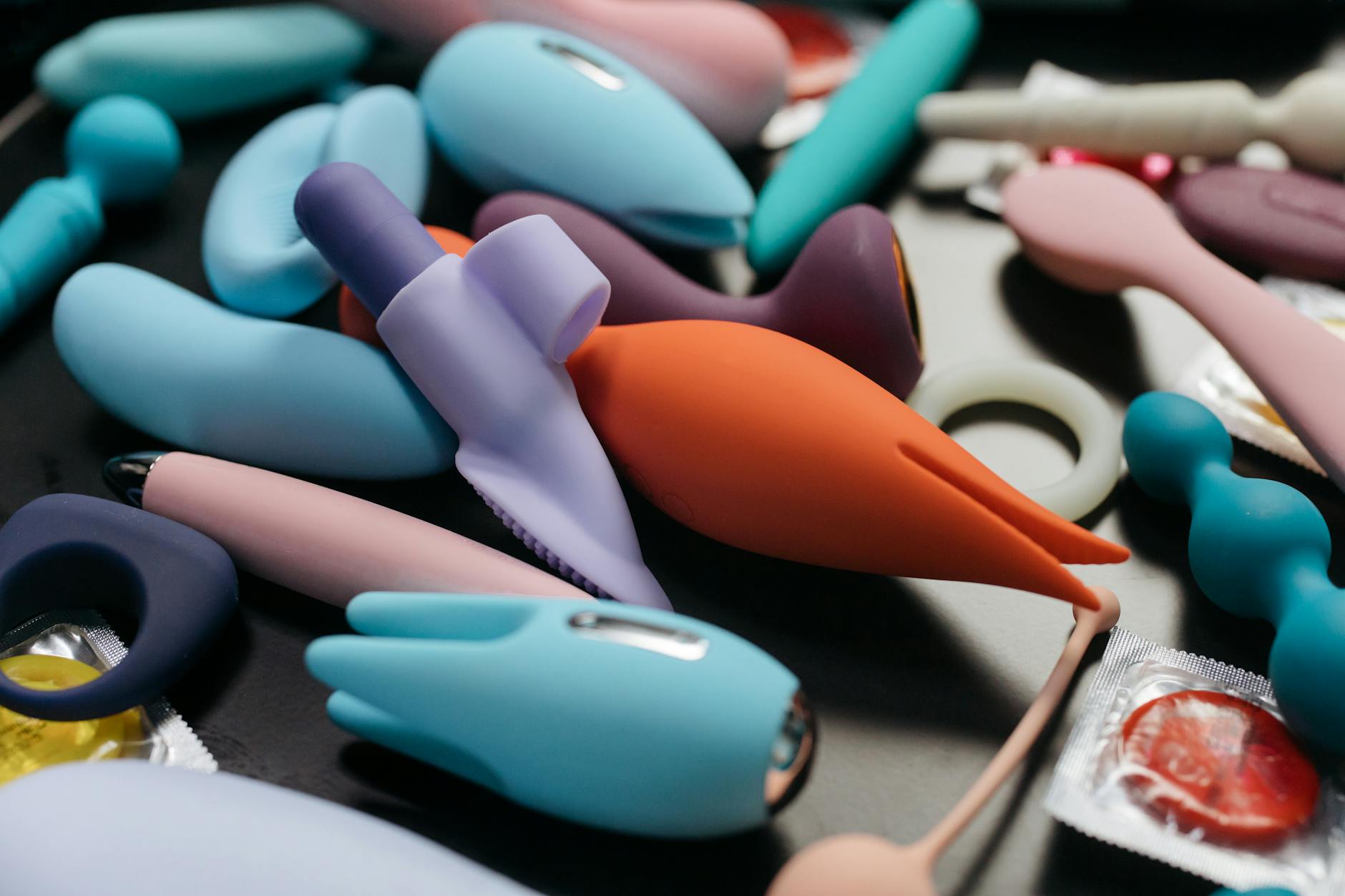 Vibrant collection of colorful adult toys displayed on a bright yellow surface