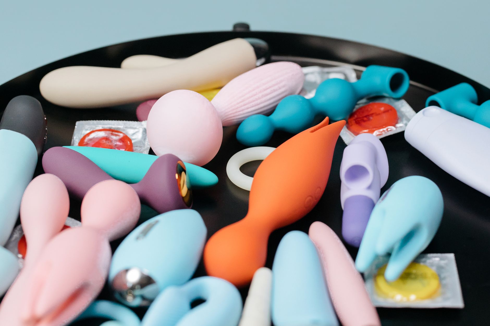 A vibrant collection of various lemon vibrators and clitoral toys on a black tray
