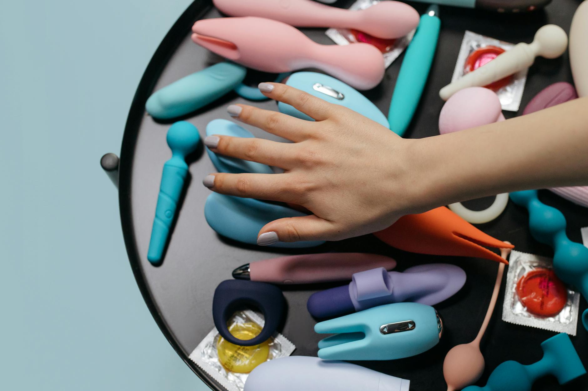 A hand holding a lemon-colored vibrator against a purple backdrop, representing modern clitoral pleasure tools