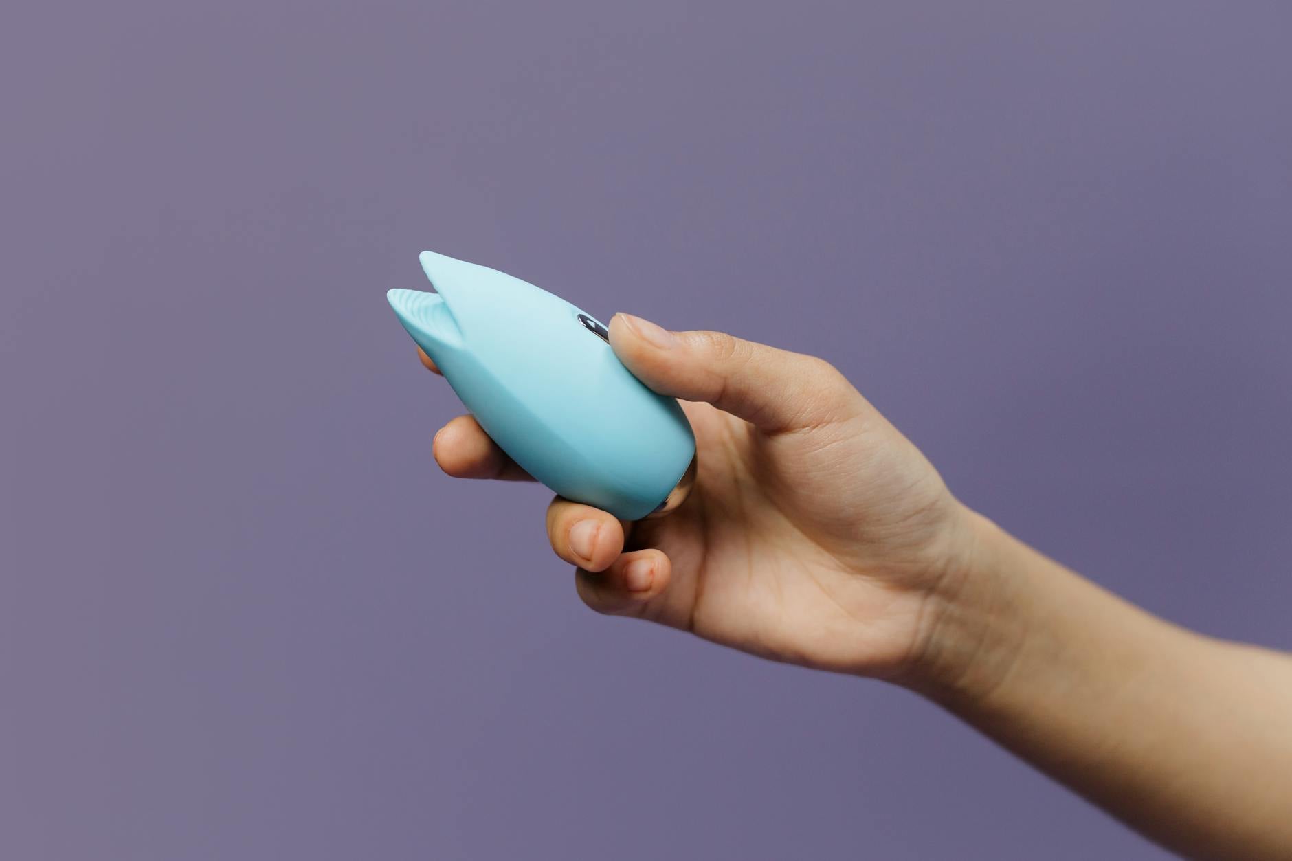 Fresh lemon halves on a pink background in sunlight, representing the citrus-inspired design of lemon clitoral vibrators.