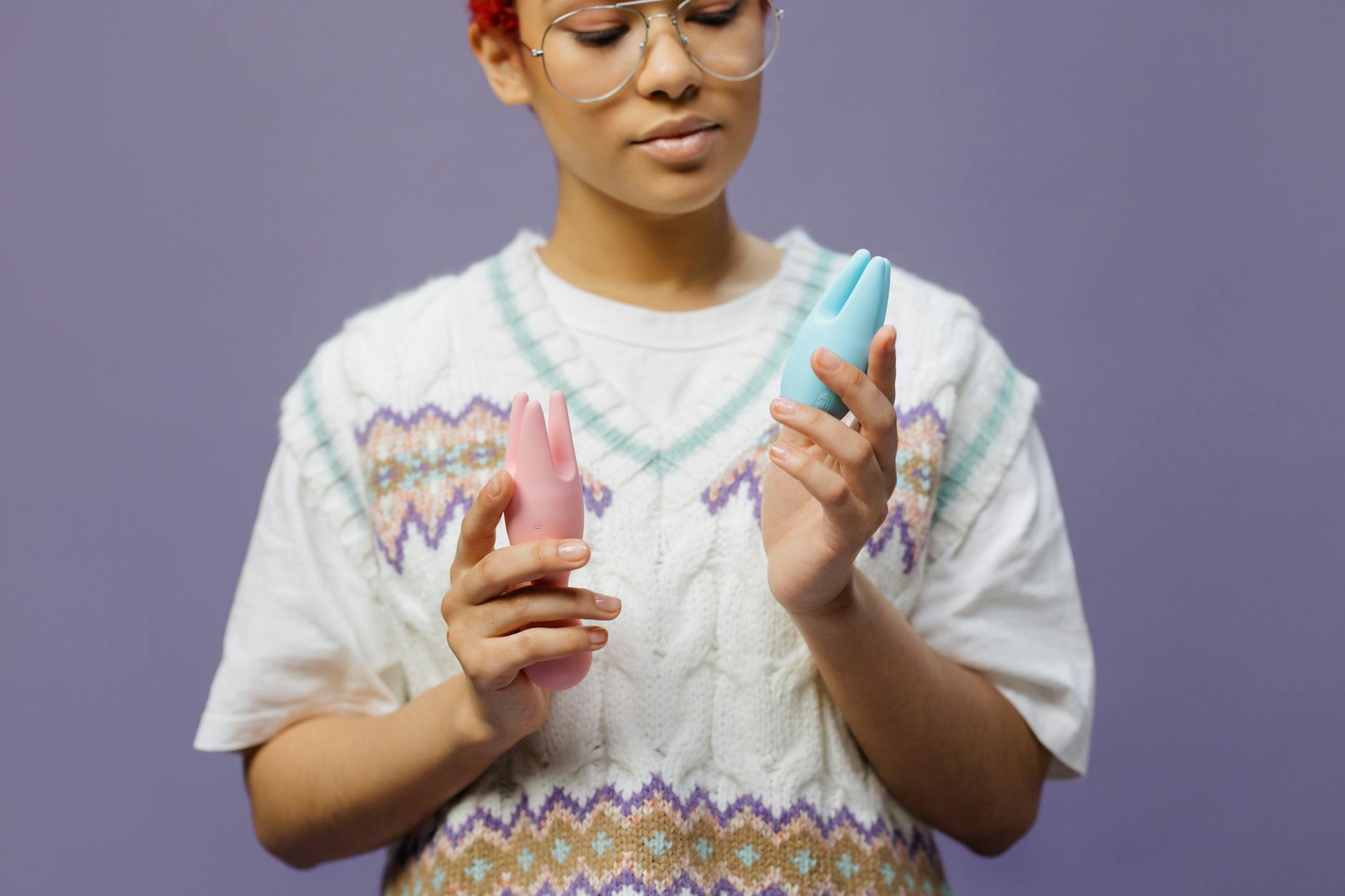 Woman holding colorful clitoral vibrators in a moment of self-discovery and pleasure
