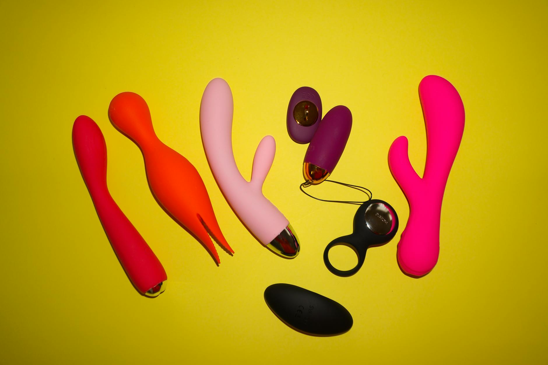 Close-up of hands holding a sleek blue vibrator against a purple background