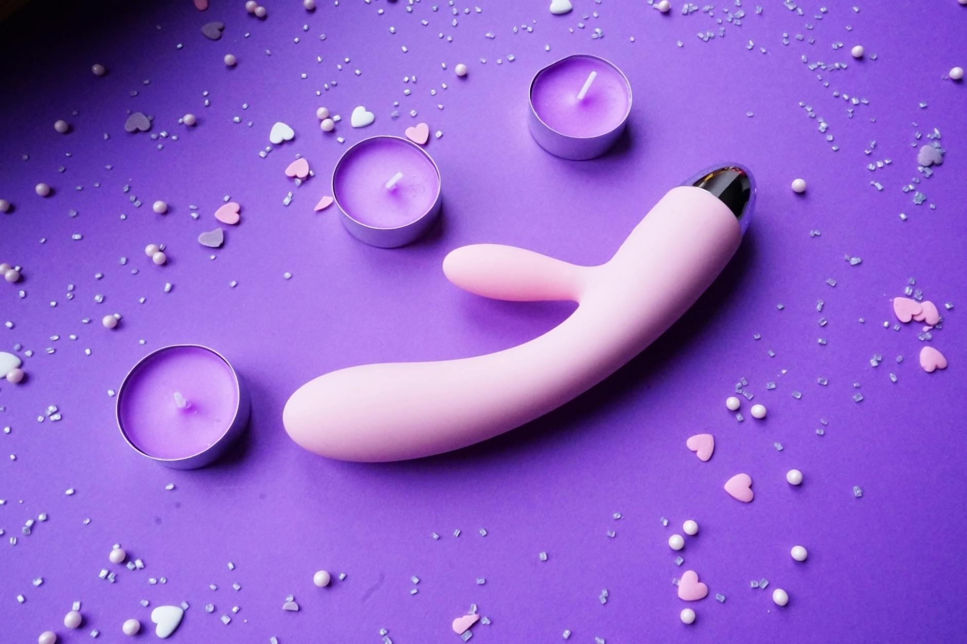Blue clitoral vibrator held in hand, symbolizing self-care and personal pleasure recovery