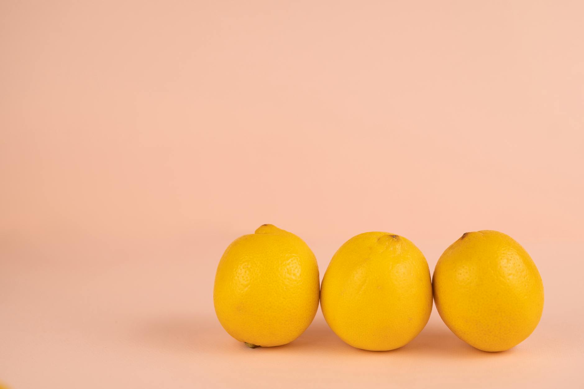Yellow silicone vibrator surrounded by fresh fruit on bright background